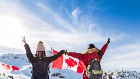 Mädchen mit Kanadaflagge über den schneebedeckten Gipfeln