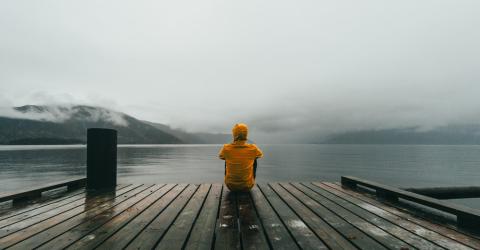 Jugendlicher auf Holzbrücke im Nebel 