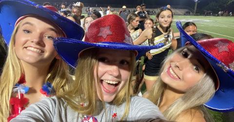 Mädchen im Cowboy-Outfit vor Footballfeld
