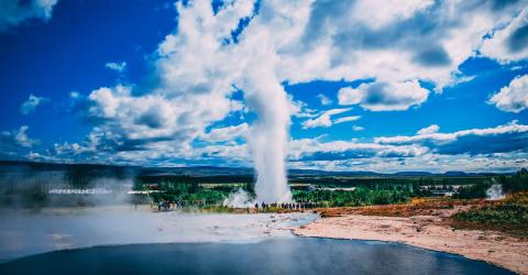 Geysir in Island baluer Himmel blaues Wasser