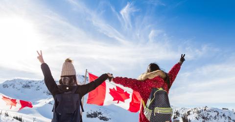 Mädchen mit Kanadaflagge über den schneebedeckten Gipfeln