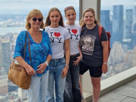 Vier Personen stehen vor der Skyline von New York