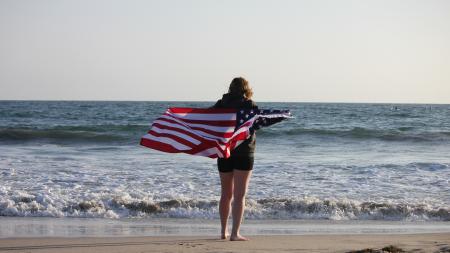 Mädchen mit USA Flagge am Strand