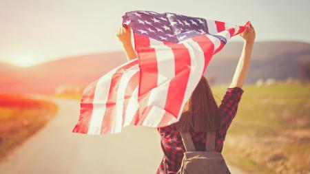 Teenager mit der USA Flagge überm Kopf 