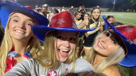 Mädchen im Cowboy-Outfit vor Footballfeld