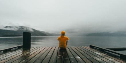 Jugendlicher auf Holzbrücke im Nebel 